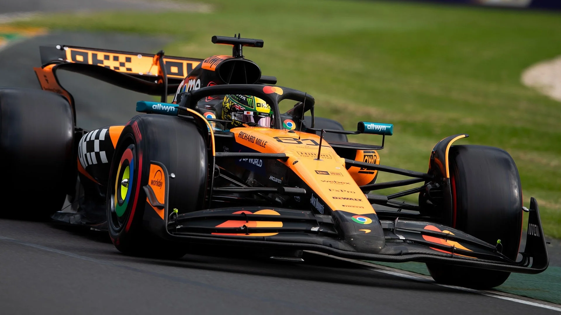 Оранжевый болид McLaren Формулы-1 в повороте на трассе
